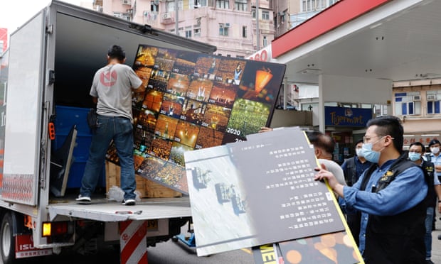Police collect an exhibition board from the June 4th Museum, which commemorates the 1989 Tiananmen Square crackdown.