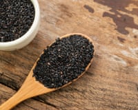 Black sesame seeds in a wooden spoon