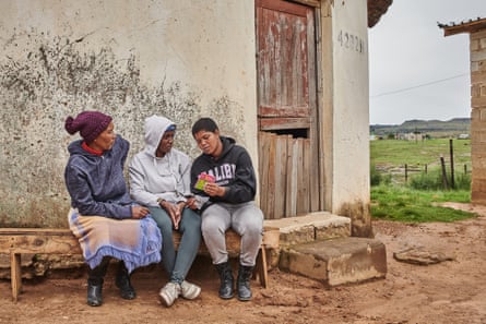 Novuyisile Msuthu, Palesa Phaketsi, and Okuhle Baso sit outside the Msuthu home in Mount Fletcher to discuss the talking book that they have been given. 