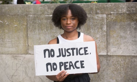 A protester holds a placard at a BLM protest in Hyde Park, London