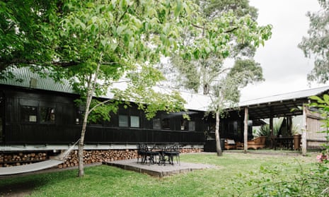 The exterior of the carriage, painted black, with a couple of trees and a hammock in the foreground