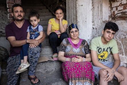 Portrait of a family sitting on the steps to their home