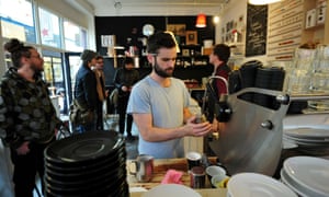 A man makes coffee at a boutique cafe in Brixton.