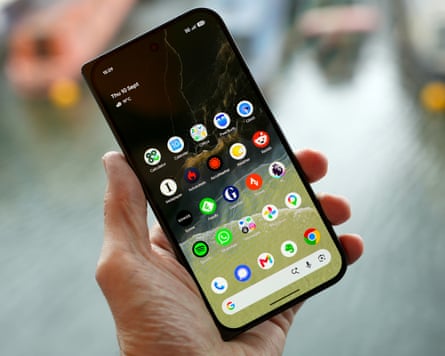 The Google Pixel 11 Pro Fold held shut in a hand showing the home screen on its outer display