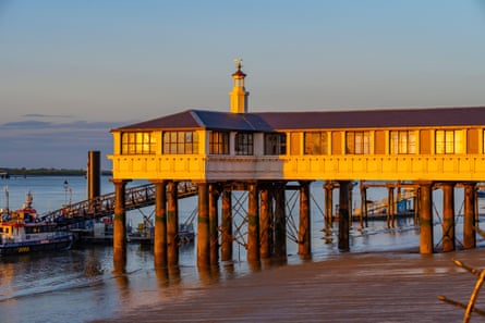 Gravesend pier at sunset, with boats moored at the end
