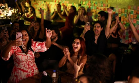 Pessoas reagem à vitória do Oscar por I'm Still Here em um bar em São Paulo.