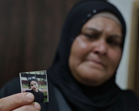 Rodayna Amuri holding up a small photo of Rimas