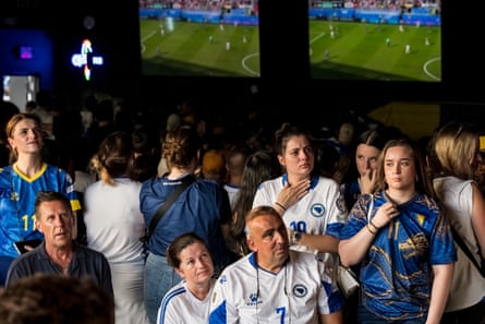 people sit and stand in a bar