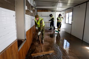 Private Ashley Jones of the Australian defence emergency support team joins NSW Rural Fire Service personnel in assisting locals with clean-up tasks at the Weeroona holiday park at Manning Point