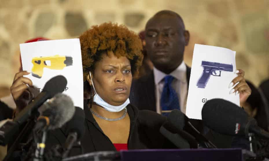 Daunte Wright’s aunt Nyesha Wright holds up two printed images depicting a Taser and a gun while discussing her nephew’s death.