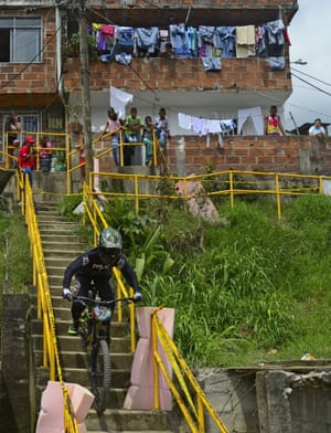 Residents watch as a downhill rider competes during the Adrenalina Urban Bike race final