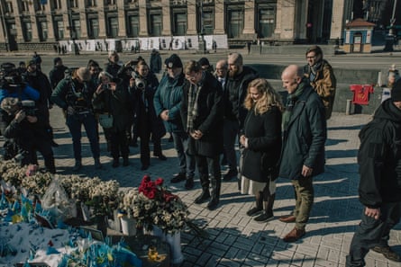 Troels Lund Poulsen and others stand looking at the memorial