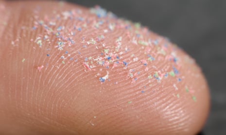 Close-up of fingertip with microplastics
