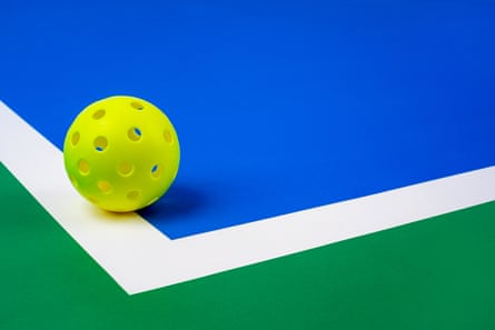 A yellow pickleball on a pickleball court