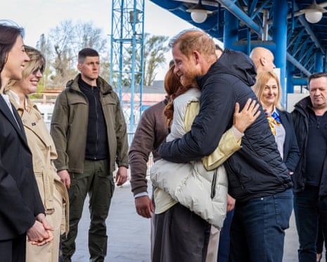 Prince Harry embraces a woman as he arrives at Kyiv railway station