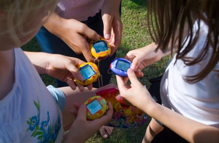 Three girls playing with Tamagotchis