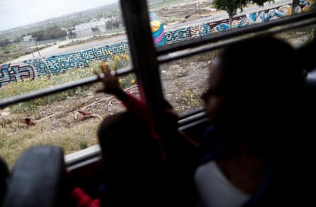 A bus rides past the border fence between Mexico and the US in Tijuana, 29 April