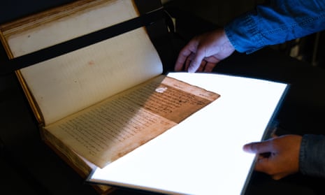 Hidden text in pages from William Camden's Annals is revealed by a light sheet.