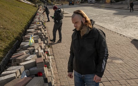 Yuriy Aksenyn beside a memorial to his father, Vasyl