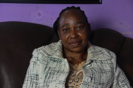 A woman in a cream jacket sits on a sofa.