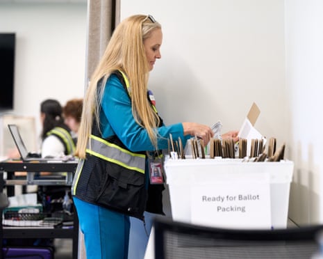A Wake County elections worker sorts absentee ballot envelopes into a bin labeled "Ready for Ballot Packing."