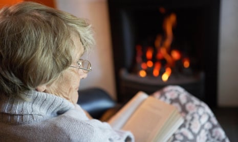 An elderly woman reading in her living room.