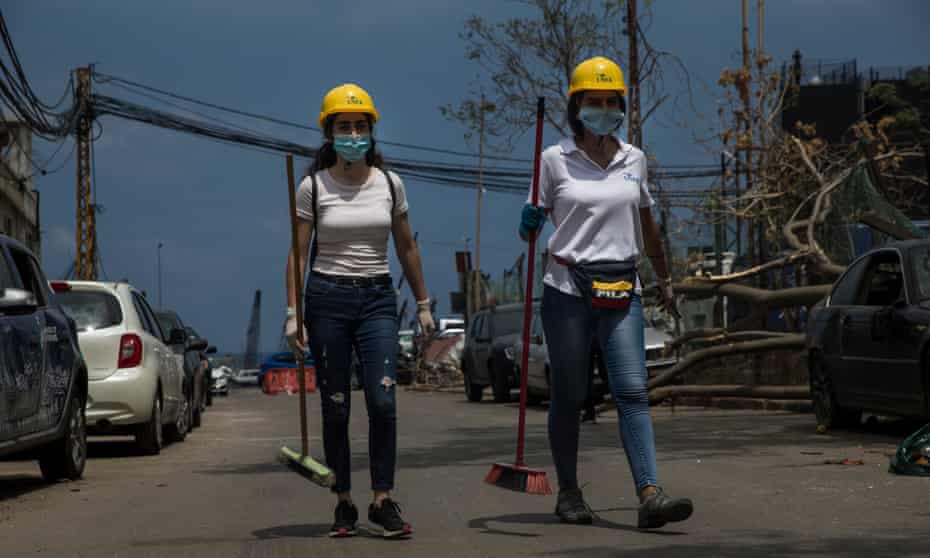 Two women carry brooms to help in the cleanup after last weeks explosion on August 13, 2020 in Beirut, Lebanon. The explosion, which killed more than 200 people and injured thousands more, is seen by many Lebanese as a deadly manifestation of government malpractice. (Photo by Daniel Carde/Getty Images)