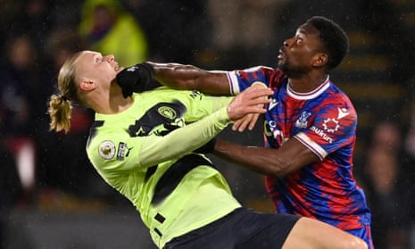 Manchester City's Erling Haaland tussles with Crystal Palace's Marc Guehi.