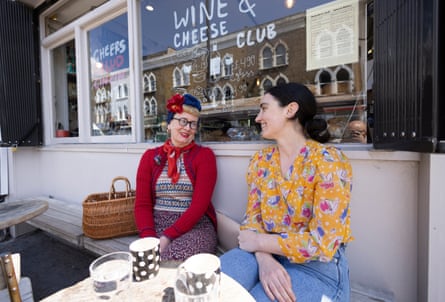 Sam Miller with another woman sitting outside a coffee shop