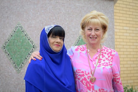 Bibi Khan and Judith Prinsley standing together outside a mosque, smiling to the camera
