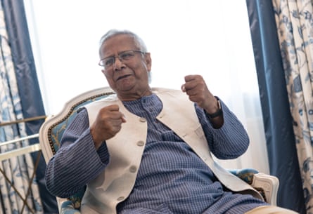 A man sits in a chair gesturing vigorously as he speaks.