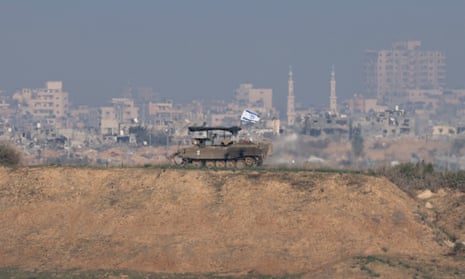 An armoured vehicle of the Israeli army patrols an area overlooking the Shujaiya neighbourhood in the Gaza Strip, near the Israeli-Gaza border in southern Israel.