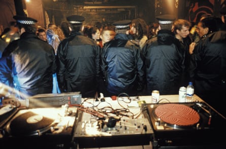 Police stand guard over the decks after busting an illegal warehouse party.