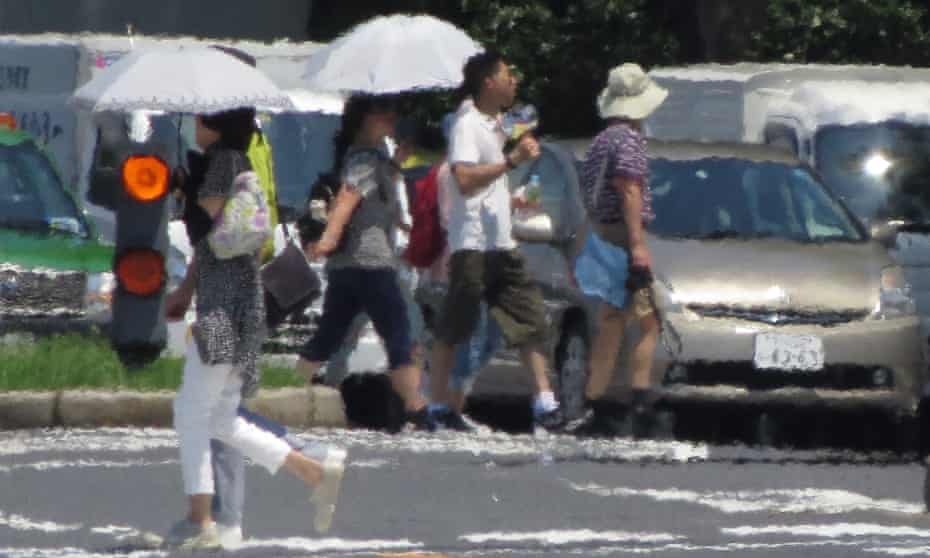 Pedestrians cross a street during the 2018 Tokyo heatwave.