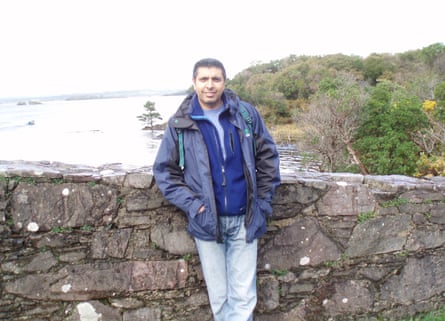 Tahir standing next to a wall with a sea view behind him.