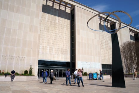 people standing outside of museum, a sculpture to the right