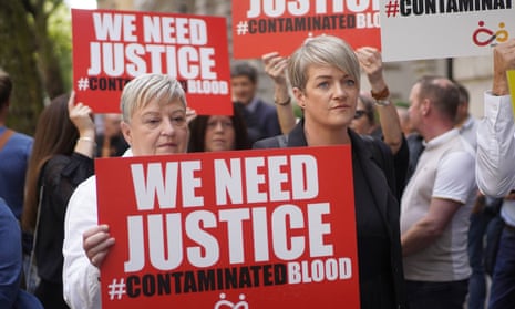 Campaigners in Westminster holding signs reading "We need justice #ContaminatedBlood"