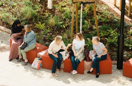 Locals chat on the new seating in Bermondsey's Blue Market made from old concrete bollards stained red.