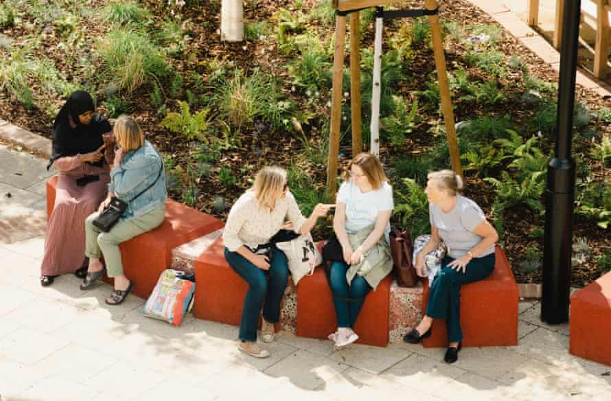 Locals chat on the new seating in Bermondsey's Blue Market made from old concrete bollards stained red.
