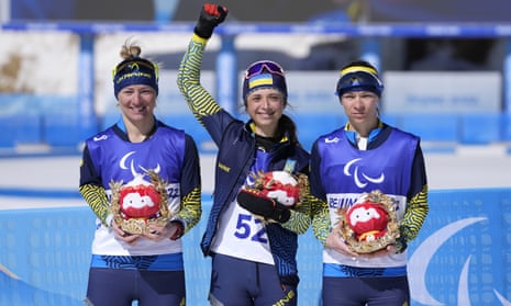 Ukraine's Iryna Bui (centre), silver medalist Oleksandra Kononova (left) and bronze medalist Liudmyla Liashenko celebrate after the women's middle-distance standing event.