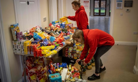 Staff organise food donations for vulnerable families at the Cooking Champions food bank in Grange Park, north London