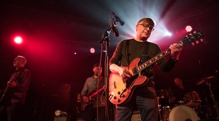 A close up of Norman Blake playing guitar on stage in 2016.