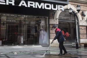 A cleaner washes the street with a high-pressure water hose