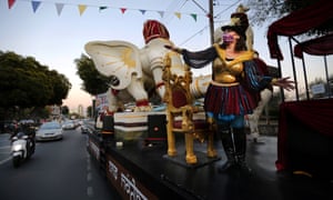 2021 년 3 월 4 일 목요일, 카니발 축제를 조직하는 지방 자치 단체 관리인 Skevi Antoniadou는 카니발 왕의 주요 부표가 2021 년 3 월 4 일 목요일에 키프로스 남부 해안 도시인 Limassol의 도로를 따라 지나가는 것을 관중에게 몸짓으로 표시합니다.