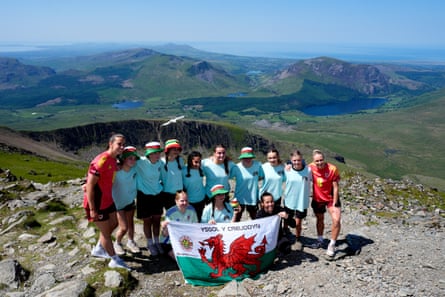 Members of Urdd Gobaith Cymru, Wales’s largest youth organisation, with players Rhiannon Roberts and Olivia Clark at the summit of Yr Wyddfa, or Snowdon, after the Euro 2025 announcement.