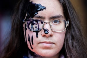 A climate activist covered with black liquid during a protest in Berlin