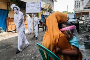 Jakarta, Indonesia. Officials dressed up as ‘pocong’ or shroud ghosts march during a Covid-19 awareness campaign at a market in Tangerang