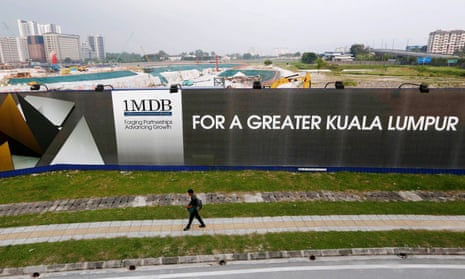 A man walks past a 1MDB billboard in Kuala Lumpur in 2015