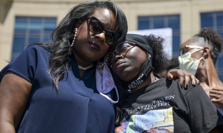 The Colorado state representative Leslie Herod, left, hugs Elijah McClain’s mother, Sheneen McClain, right, as they stand with protestors on 27 June.