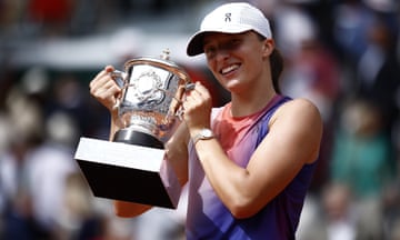 Iga Swiatek poses with the trophy after winning the French Open final against Jasmine Paolini.